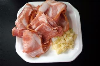 准备培根肉片，蒜头切碎。