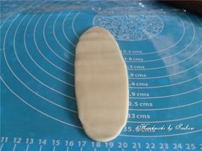 静置好的油酥皮，取出旋转90°，再擀成牛舌状