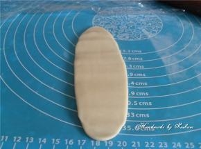 静置好的油酥皮，取出旋转90°，再擀成牛舌状