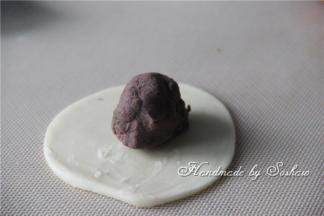 取一个油酥皮，压扁，将红豆馅包圆