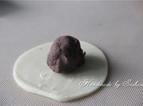 取一个油酥皮，压扁，将红豆馅包圆