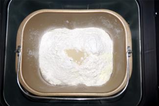 将清水，糖，全麦面粉，奶粉，酵母放入面包机。