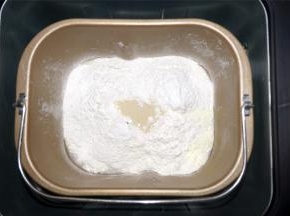 将清水，糖，全麦面粉，奶粉，酵母放入面包机。