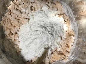 3.加入200克面粉搅拌成絮状。