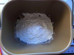 将高筋面粉，低筋面粉，鸡蛋，泡打粉放入面包机，开启和面程序