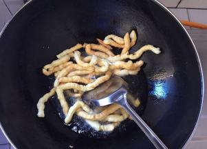 锅中放入玉米油烧至150度左右，将胚条分次投入油锅里炸成金黄色（如果觉得油温不好把握，可以先扔一条胚条到油锅里试试，如果胚条很快浮起来并膨胀，就表示油温可以了）