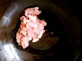 锅中放油，把鸡腿块儿倒进去翻炒。