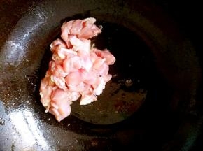 锅中放油，把鸡腿块儿倒进去翻炒。