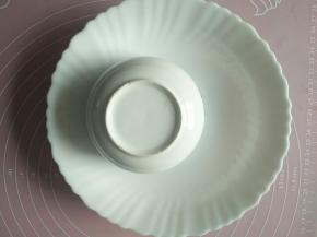 把米饭装入小碗中，然后倒扣在盘子中。