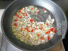 倒掉多余油，放入切碎的洋葱，葱段，蒜瓣，辣椒，煸炒变软