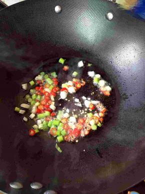热锅凉油，下葱、小米椒小火煸香。