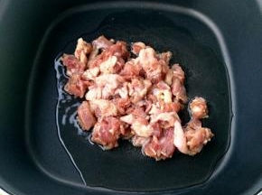 油温烧至五成热，下腌好的鸭肉。