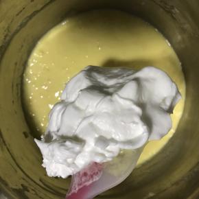 5.将打发好的蛋白取三分之一加入到蛋黄面糊中，翻拌均匀