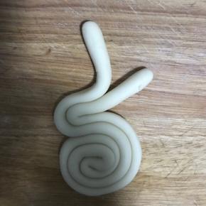 12.由头部开始盘，耳朵分开，折出兔子头部形状，然后剩余的从尾部盘起收好，做成兔子身子