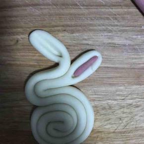 13. 将兔子的耳朵用筷子压出沟槽，将粉色面团揉细条，切断，填充耳部！及做成眼睛