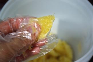 带上手套，对鲜橙果肉稍微捏一下，让包裹橙汁的壁膜破裂。