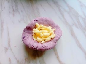 取一小块面团，用手心压扁，加入马苏里拉芝士，包包子的手法抱起来，收口朝下，捏紧，揉圆。