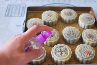 烤箱上下火180度预热。月饼入炉烘烤前先喷点水（不要直接对着喷，离远点喷，让水雾沾上去即可）。