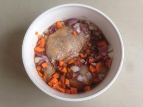 将鸡腿翻面，将红葱头粒和胡萝卜粒倒入，继续腌半个小时