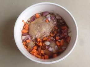 将鸡腿翻面，将红葱头粒和胡萝卜粒倒入，继续腌半个小时