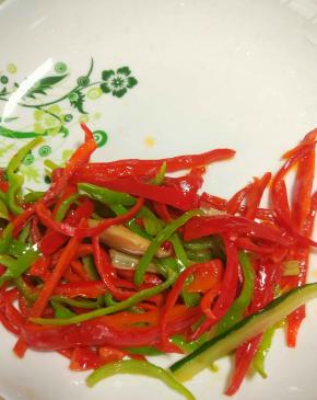 热锅凉油把青红椒炒断生，铲出备用。