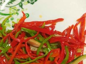 热锅凉油把青红椒炒断生，铲出备用。
