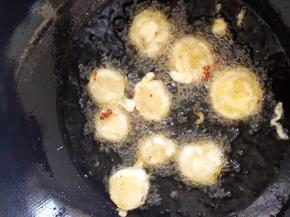 锅中倒入油，烧至八成热时将荸荠一个个夹入其中炸至双面金黄