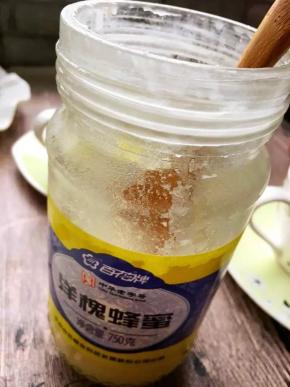 挖两勺蜂蜜倒入杯子中