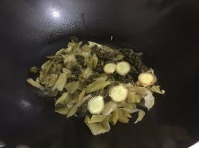 5. 码入姜片和酸菜翻炒