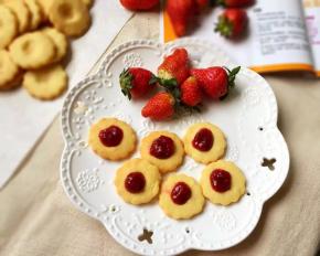 取出晾凉，在每个饼干的小窝上挤上草莓酱