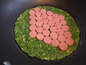 小火，待底部稍凝固，将切好的香肠片摆在上面，随意摊平摆上就可以