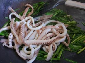 倒入鱿鱼须，加盐，料酒和生抽，快速翻炒