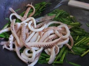 倒入鱿鱼须，加盐，料酒和生抽，快速翻炒