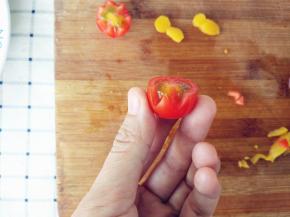 将圣女果洗净，横向对半切开，用小刀如图刻出花瓣，完成后备用