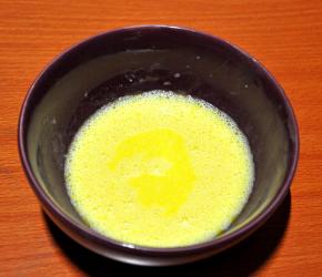 2、蛋黄加入白糖（10克）、牛奶和玉米油搅拌均匀