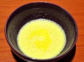 2、蛋黄加入白糖（10克）、牛奶和玉米油搅拌均匀