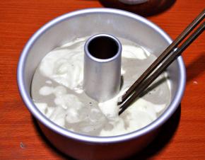 8、将原味面糊和可可面糊交替放入模具中，用筷子将其搅2圈，在桌子上轻轻振 出内部的气泡