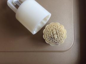 在烤盘上压出月饼，在表面喷一层清水。（离月饼有一定的高度，不是直接喷在月饼上）