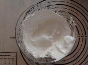 将面粉混合物和糖粉的三分之一筛入到打发好的蛋白里，利用切拌的手法充分混合