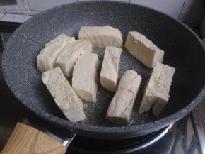 麦饭石锅加油，加热，放入豆腐条