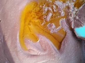 6、当红豆泥中的水分消失一部分时，加入大豆油，继续不停的搅拌翻炒。