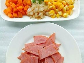 胡萝卜粒，玉米粒提前焯水，火腿片不放油放锅中煎至两面微黄切块，青椒粒，洋葱粒放入锅中炒片刻