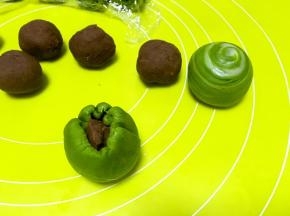 包裹上豆沙馅，用虎口一点点向上推面，将收口捏紧收好