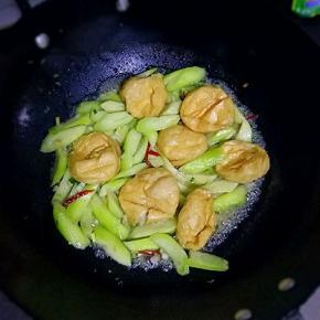 放入油面筋，青椒翻炒均匀，油面筋会吸收汤汁，加入适量盐，生抽调味，最后加1勺鸡精翻炒均匀