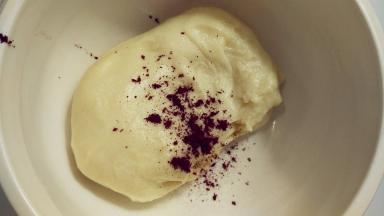 和好的油皮平均分成两份，其中一份加入红曲粉，将它们揉和均匀。