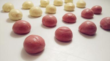 两种颜色的油皮分别均分成10份，滚圆后盖上保鲜膜备用。