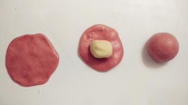 取一份油皮，用擀面杖擀成圆形，在中间放上一份油酥，像包包子一样包好，收口记得捏紧。全部的油皮都这样处理。