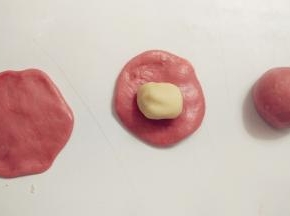 取一份油皮，用擀面杖擀成圆形，在中间放上一份油酥，像包包子一样包好，收口记得捏紧。全部的油皮都这样处理。