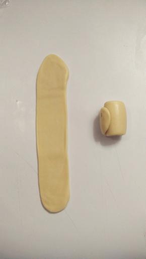 接着来做第二次擀卷，一样将面团收口朝上，用擀面杖擀开，这一次尽量擀成长方形的条状。