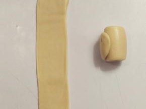 接着来做第二次擀卷，一样将面团收口朝上，用擀面杖擀开，这一次尽量擀成长方形的条状。